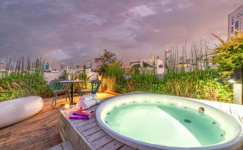 uma banheira num deque com vista para a cidade em Shenkin Hotel em Tel Aviv