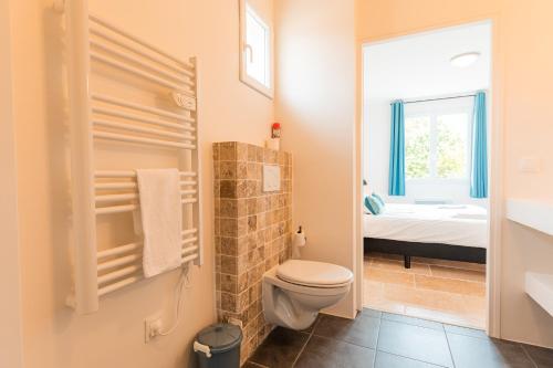 ein kleines Bad mit WC und ein Schlafzimmer in der Unterkunft Les Forges Villas - 5 room villa for 8 people in Vasles