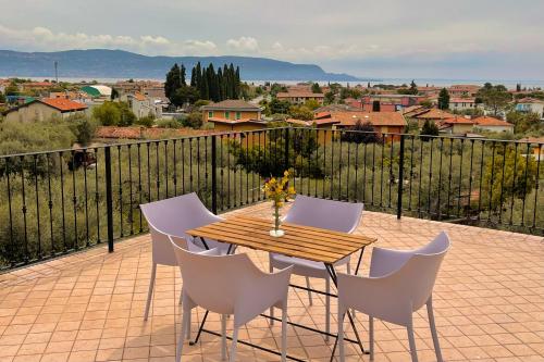 a wooden table and white chairs on a balcony at Albergo Vittoria in Toscolano Maderno