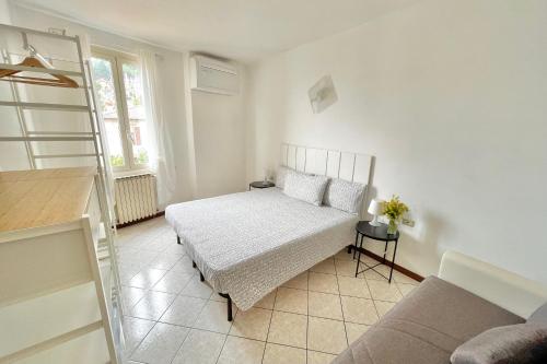 a white bedroom with a bed and a window at Albergo Vittoria in Toscolano Maderno