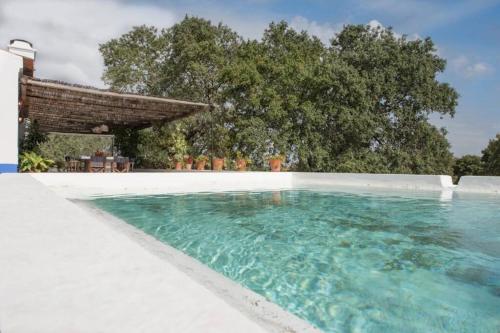 a swimming pool with turquoise water at MONTE DO CORTIÇO in Arraiolos