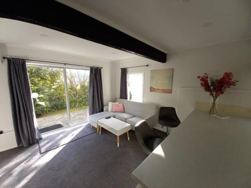uma sala de estar com um sofá e uma mesa em Lemon Tree Apartment Tawa em Wellington