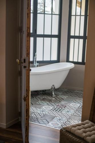 a bath tub in a bathroom with a window at Hotel Galla Placidia in Narbonne