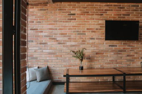 a brick wall with a couch and a tv at Hotel 3450 Living Lofts in Medellín