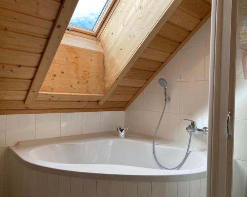 uma banheira na casa de banho com uma clarabóia em Ferienwohnung Lechglück em Pflach