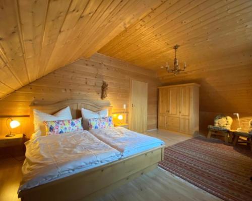 - une chambre avec un grand lit et un plafond en bois dans l'établissement Ferienwohnung Lechglück, à Pflach