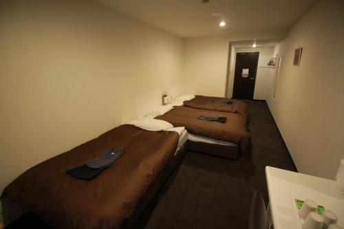 a room with two beds in a room at Takamatsu Century Hotel in Takamatsu