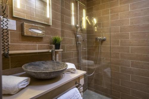 a bathroom with a sink and a shower at Oxigén Family Hotel Noszvaj in Noszvaj