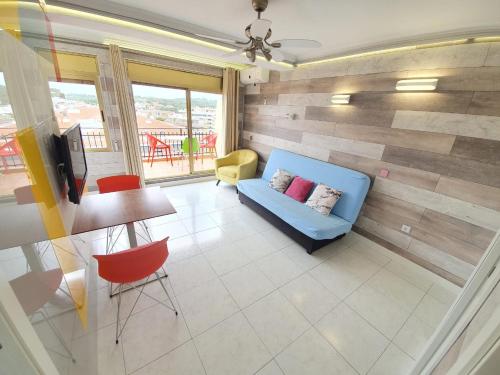 sala de estar con sofá azul y mesa en Apartamento en Salou con las vistas al Port Aventura, en Salou