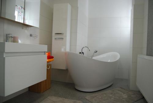 La salle de bains blanche est pourvue d'une baignoire et d'un lavabo. dans l'établissement Ferienwohnung Polzer, à Hörmanns bei Weitra