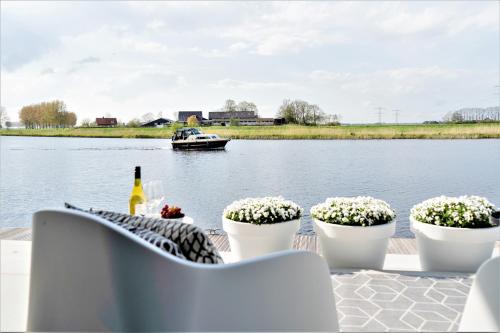 a table with flowers and a boat in the water at B&B Ganzendiep aan het water in Grafhorst