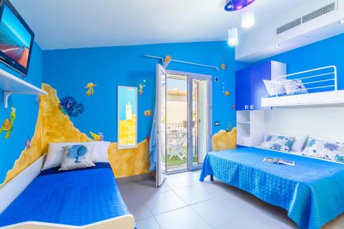 um quarto azul com 2 camas e uma parede de peixe em Sunset Bay Tecno Home Sardinia em Valledoria