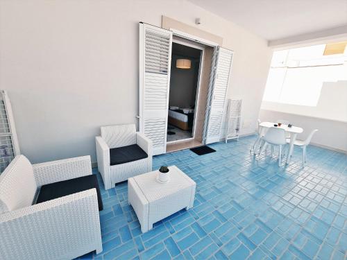 a living room with a blue tile floor at Kalinifta Rooms Apartment in Torre Lapillo