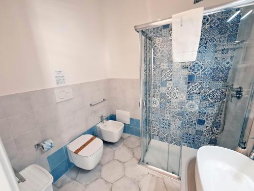 a bathroom with a shower and a toilet and a sink at Kalinifta Rooms Apartment in Torre Lapillo