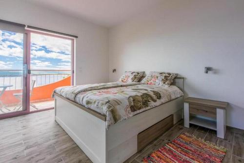 ein Schlafzimmer mit einem Bett und einem großen Fenster in der Unterkunft Apartmani Rino in Dramalj