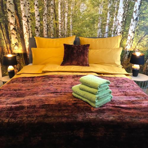 a bed with some green towels on top of it at Apartment-47 Fulda in Fulda