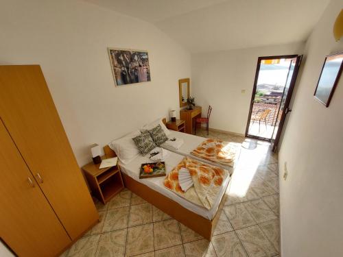 a small bedroom with a bed and a window at Apartmani Dalex in Budva