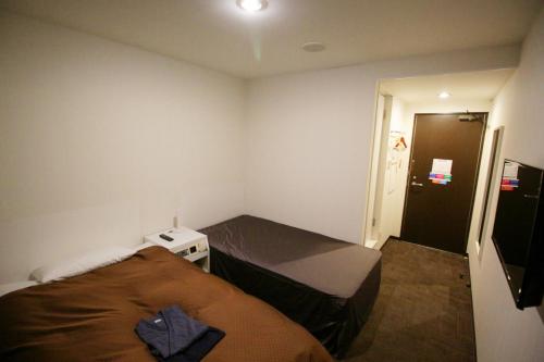 a small bedroom with a bed and a door at Takamatsu Century Hotel in Takamatsu