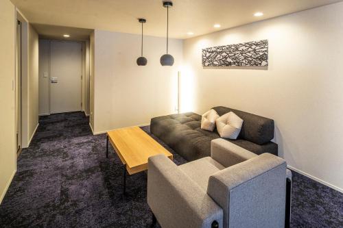 a living room with a couch and a table at RESI STAY Mayu Grace Hotel in Kyoto