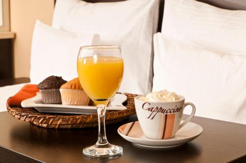 a tray with a glass of orange juice and a cup of coffee at City Boutique Hotel in Sarajevo