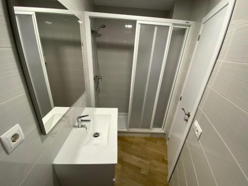 a white bathroom with a sink and a mirror at Apartamento Playa I Inmomart in Peñíscola