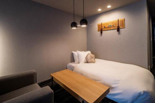 a small room with a bed and a table at RESI STAY Mayu Grace Hotel in Kyoto