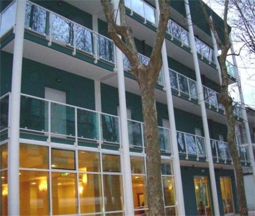 a large green building with a tree in front of it at Hotel Jole in Cesenatico