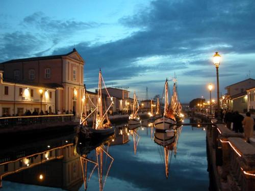 a group of boats docked in a canal at night at Hotel Jole in Cesenatico
