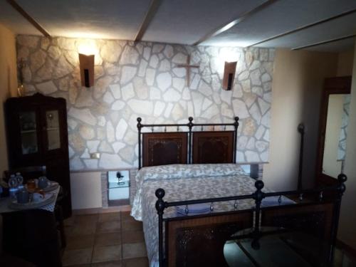 a bedroom with a bed and a stone wall at Montanari Agrivillage in Narni