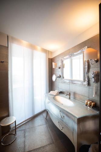 a bathroom with a sink and a mirror at Laguna Palace Hotel Grado in Grado