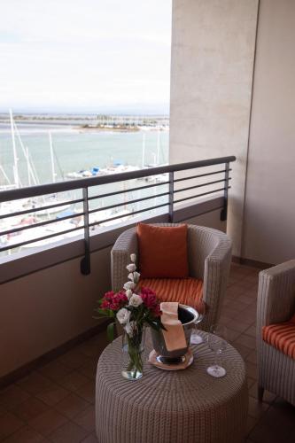 a room with a chair and a table with flowers on it at Laguna Palace Hotel Grado in Grado