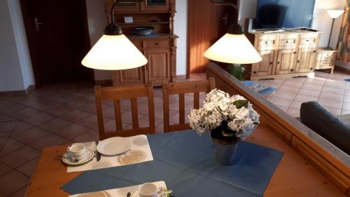 salon z 2 lampami i stołem z kwiatami w obiekcie Appartment Haus Glowe - Wohnung 11 - 300 m zum Strand w mieście Klein Gelm