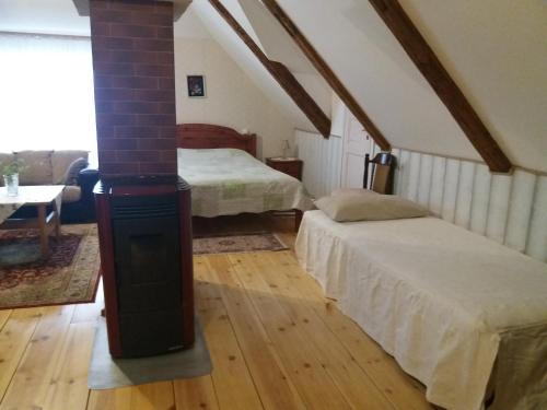 a attic room with two beds and a wood stove at Mulgi Apartment in Viljandi