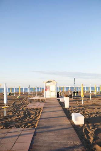 a small building on a beach with a pier at Laguna Palace Hotel Grado in Grado