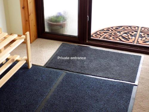una habitación con un par de alfombras azules frente a una ventana en Bosta 12 Knock, en Stornoway