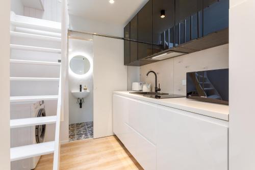 a white kitchen with a sink and a counter at Villa Aia Apartment in Pärnu