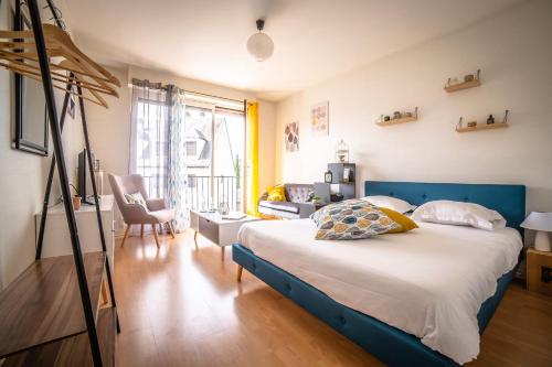um quarto com uma cama com uma cabeceira azul em ROOSEVELT #7 - Studio coquet - 1 chambre em Brive-la-Gaillarde