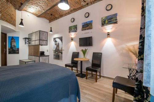 a bedroom with a bed and a table and chairs at Rose - Apartamenty Kleparskie in Krakow