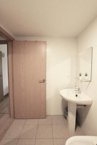 a bathroom with a sink and a wooden door at Apartamento Labegain 5 in Sestao