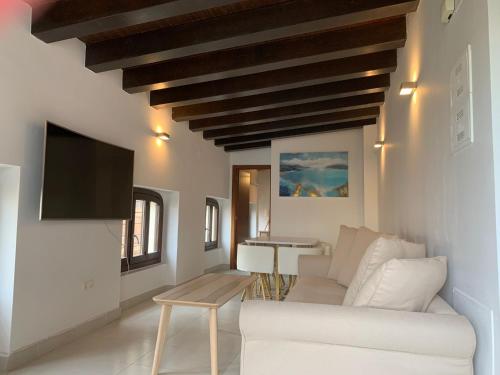 a living room with a white couch and a tv at Plaza Negrito Apartments in Valencia