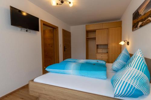 - une chambre avec un lit doté d'oreillers bleus et blancs dans l'établissement Apart Elluto, à Sölden