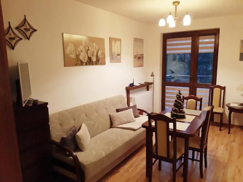 a living room with a couch and a table at APARTAMENT NATALKA przy plaży in Krynica Morska