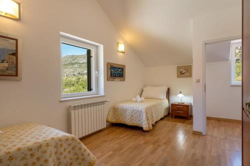 a bedroom with two beds and a window at Villa Roglic in Župa