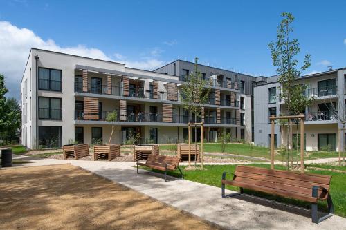 a large building with benches in front of it at Résidence Les Tisserands - Domitys in Beauvais