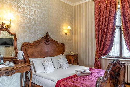 a bedroom with a bed with a wooden head board at Feder Boutique Hotel in Lviv