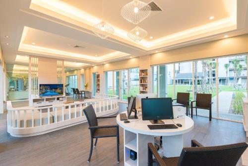 an office with a computer on a table with chairs at The Waters Khao Lak by Katathani - SHA Extra Plus in Khao Lak
