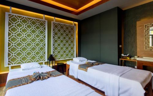 two beds in a room with green walls at The Waters Khao Lak by Katathani - SHA Extra Plus in Khao Lak