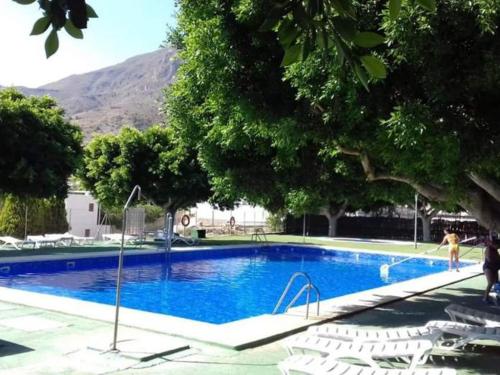 una grande piscina con sedie bianche e una montagna di La casita de la vito a Illar