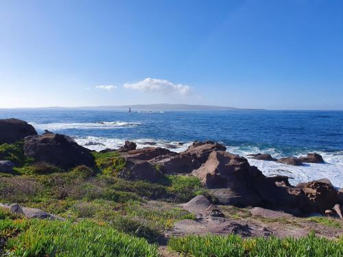 a view of the ocean from a rocky beach at La luna nel pozzo in Portoscuso