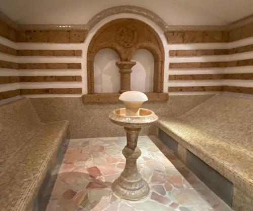 a room with benches and a table with a lamp at Spa Residence Carbona Apartman 104 in Hévíz